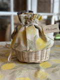 Wicker basket with a fabric cover featuring lemon design, on a matching tablecloth.