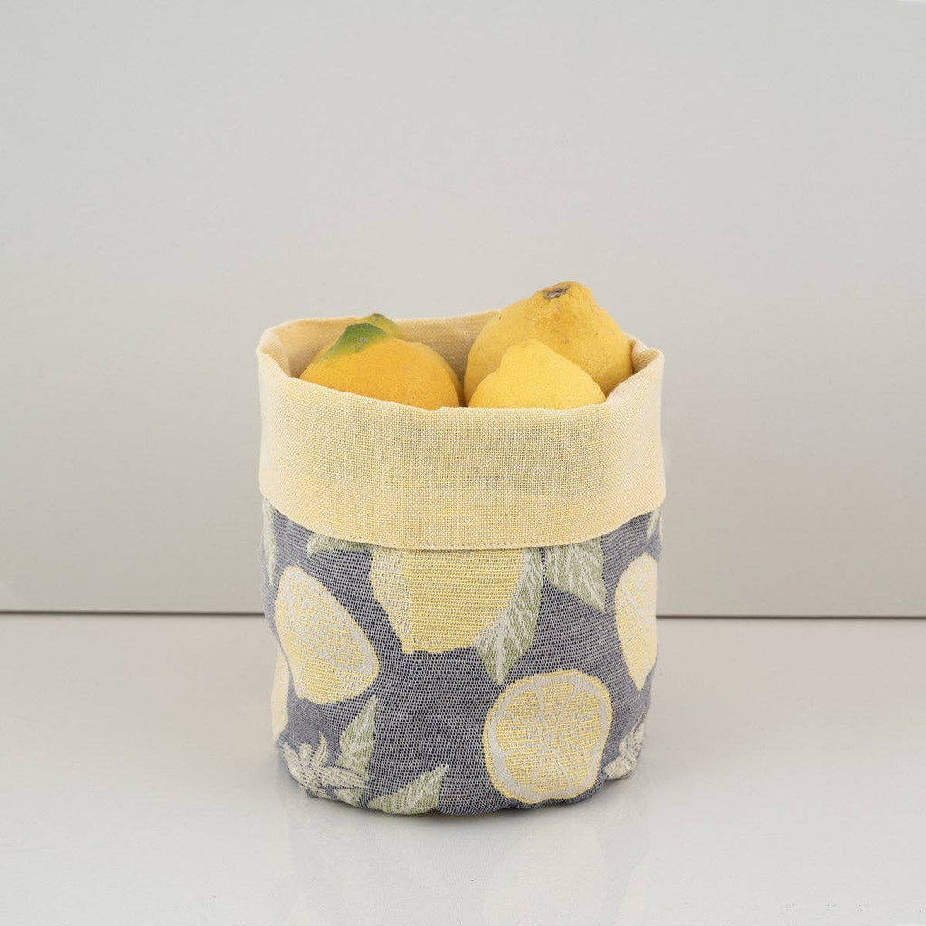 Fabric basket with lemon pattern containing lemons on a light background
