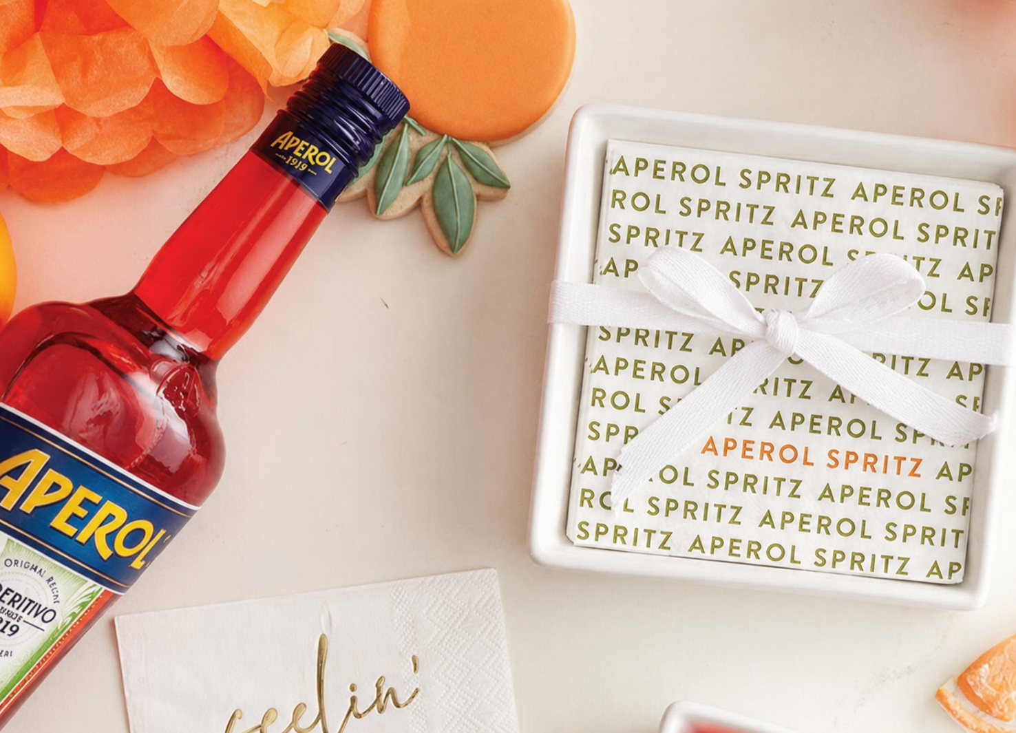 Aperol bottle with decorative coasters on a light surface