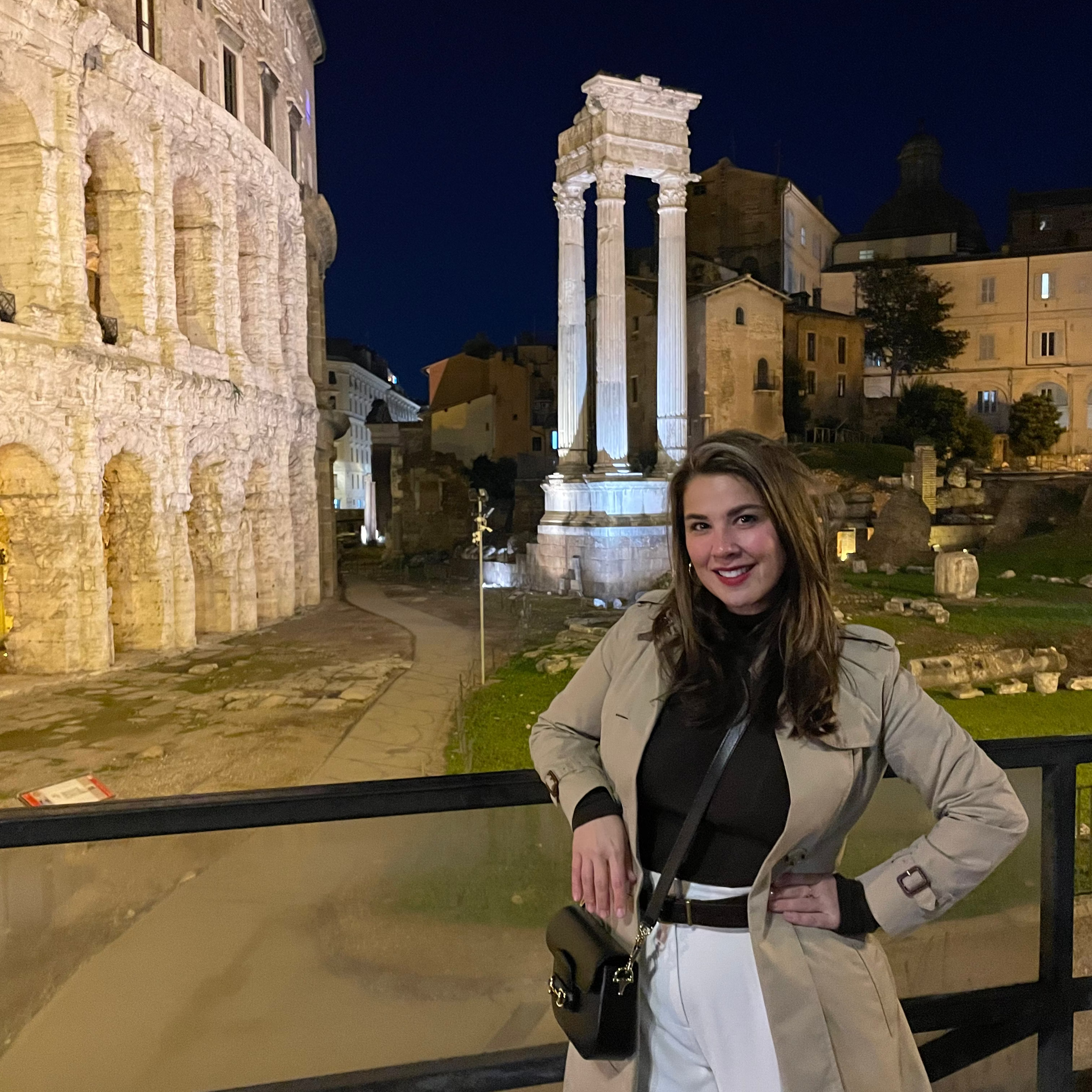 Woman posing in front of ancient Roman forum at night